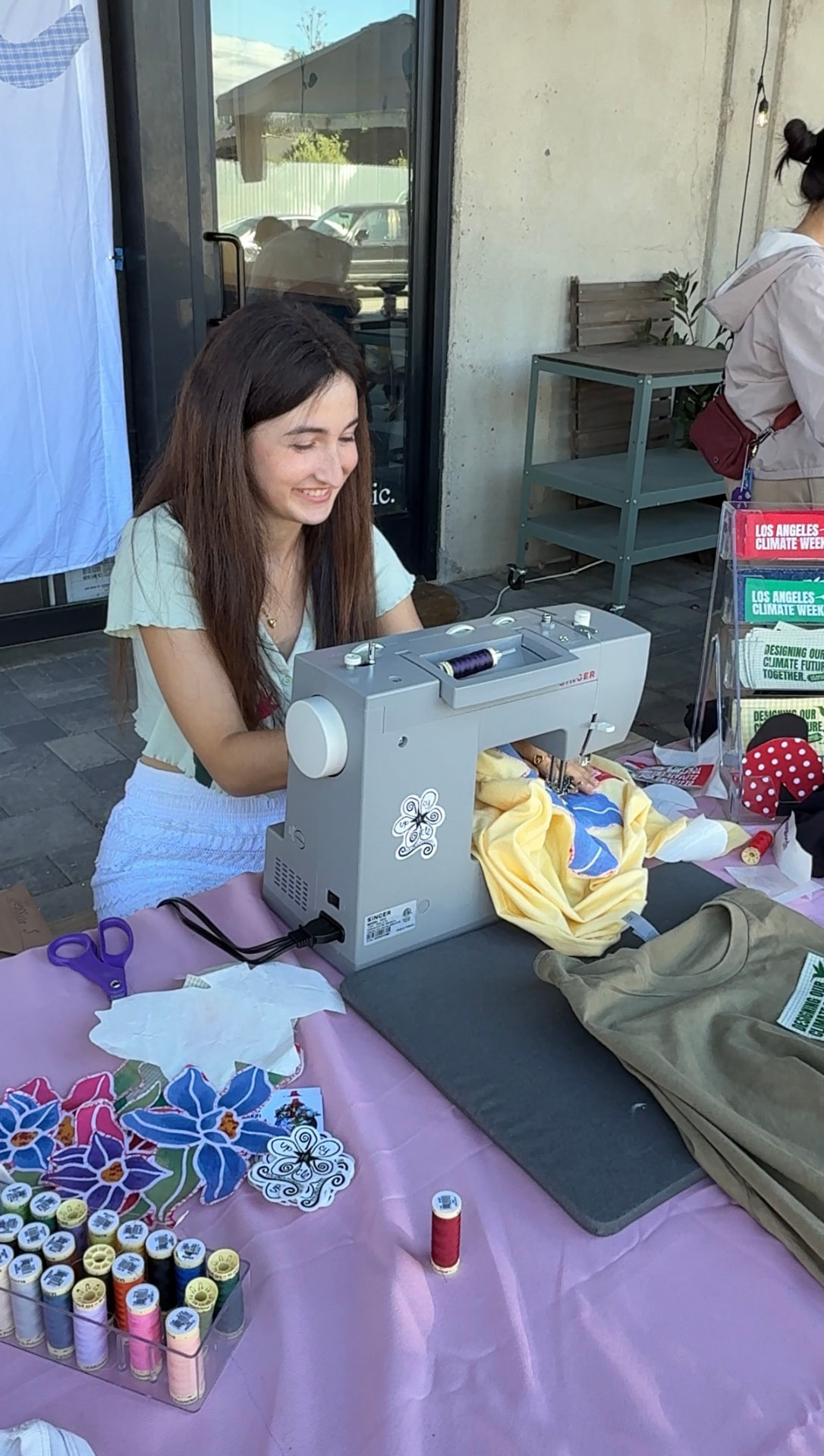 Maker sewing a yellow garment at the upcycle bar